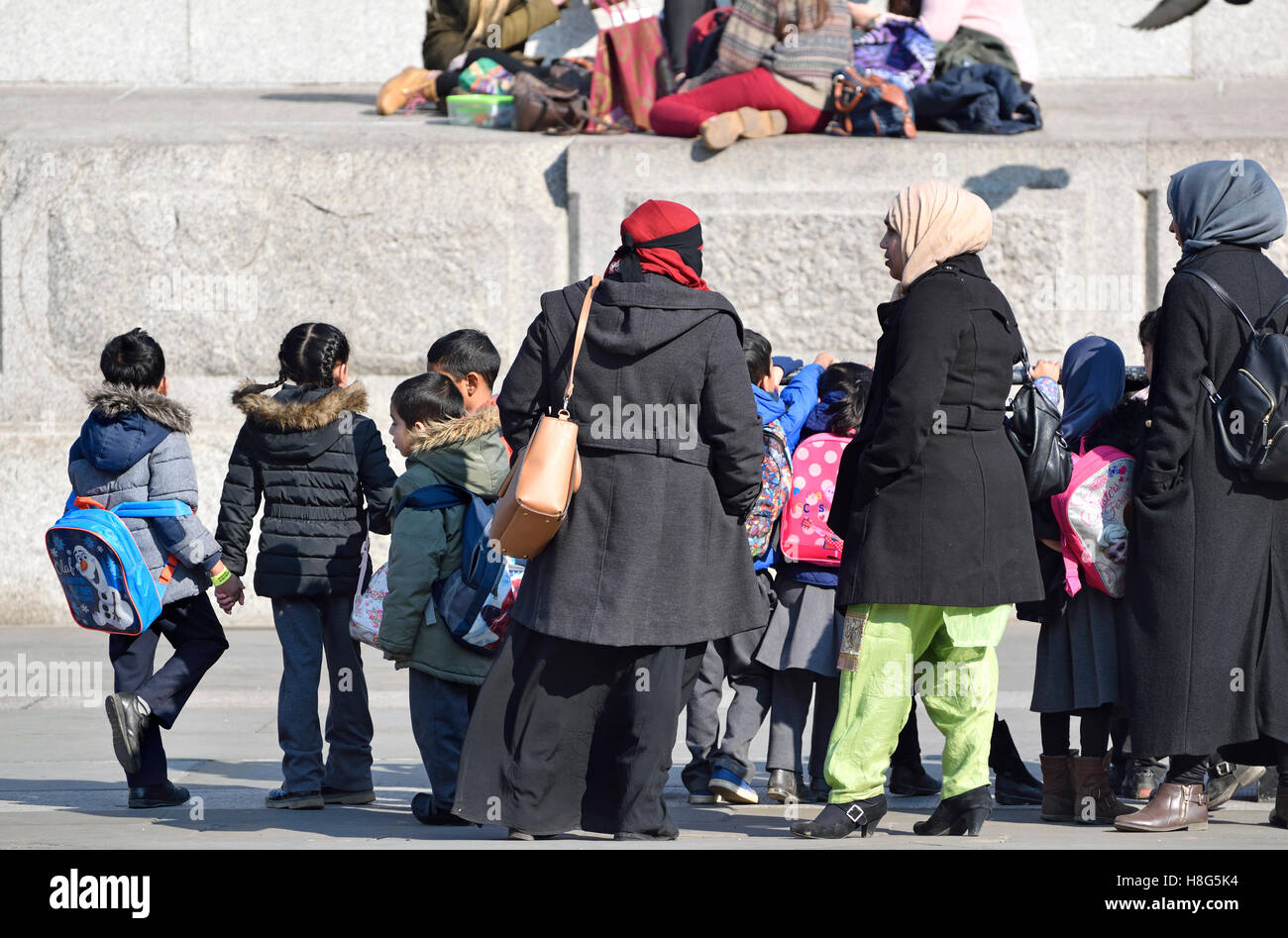 Londra, Inghilterra, Regno Unito. Le donne musulmane e i bambini in gita scolastica in Trafalgar Square Foto Stock