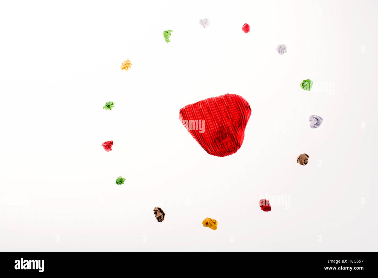 Colorata carta sgualcita formano un cerchio con la forma di cuore in esso Foto Stock