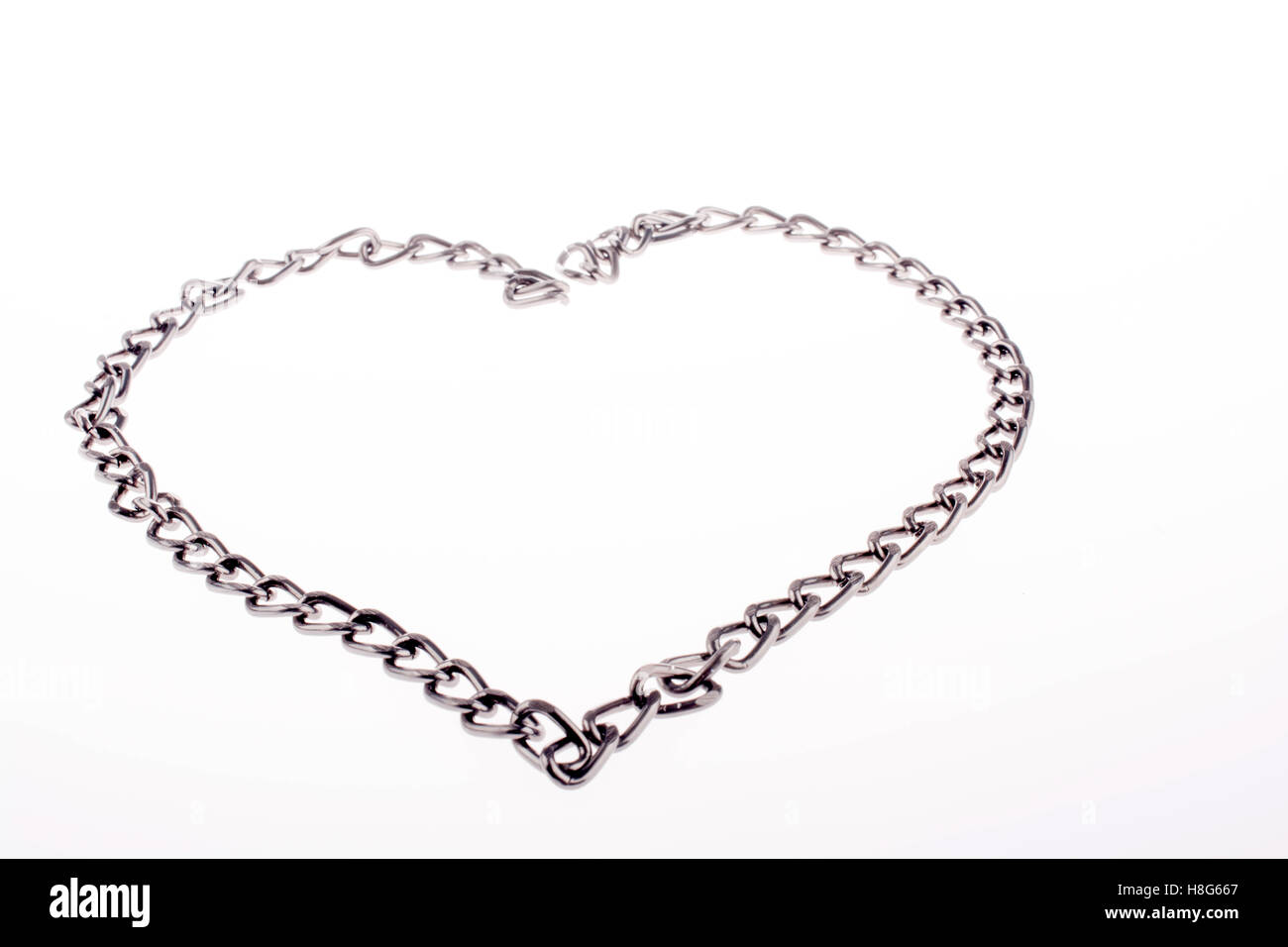 Forma di catena a forma di cuore e la parola amore sull'erba Foto Stock