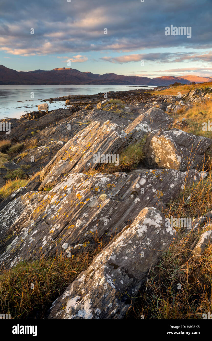 Massi lungo il Loch Linnhe sono illuminati dal sole al tramonto. Foto Stock