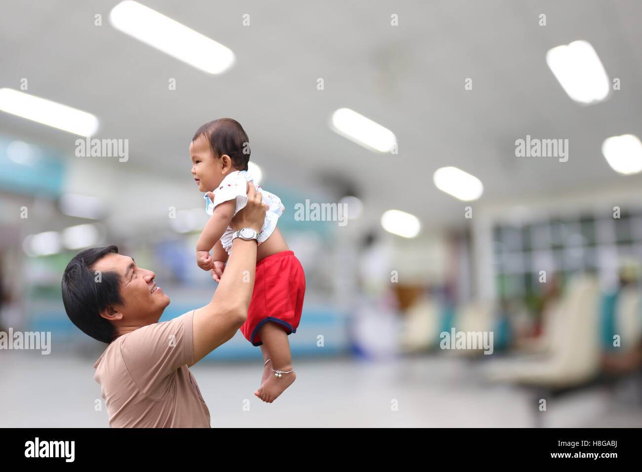 Uomo erano in possesso di un bambino a contiene fino e sfocata sullo sfondo dell'ospedale,concetto di amore nella famiglia. Foto Stock