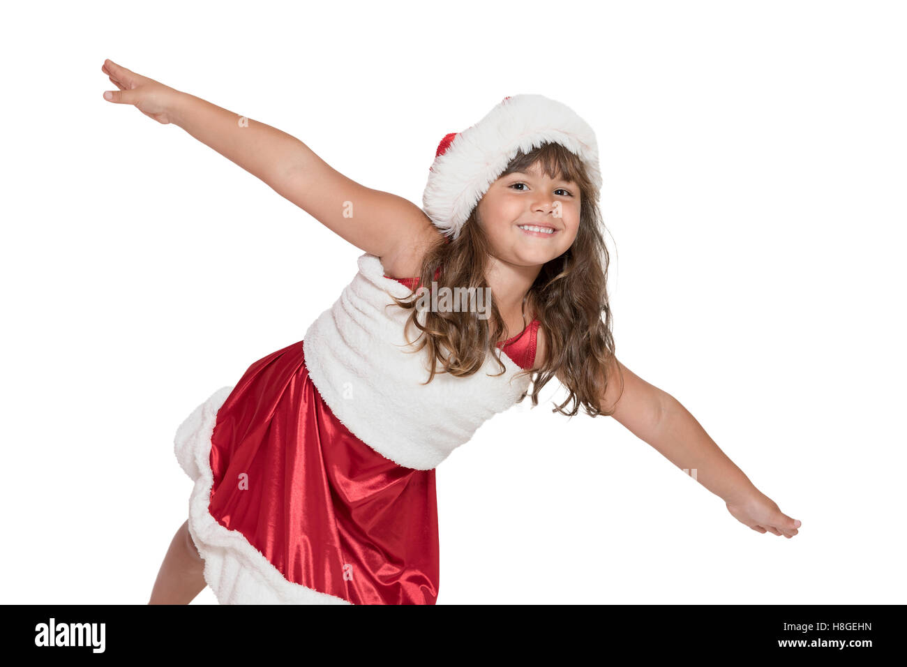 Carino sorridente bambina Santa Claus costume è inclinato in avanti nella parte anteriore della fotocamera con le braccia aperte. Tutti è iso Foto Stock