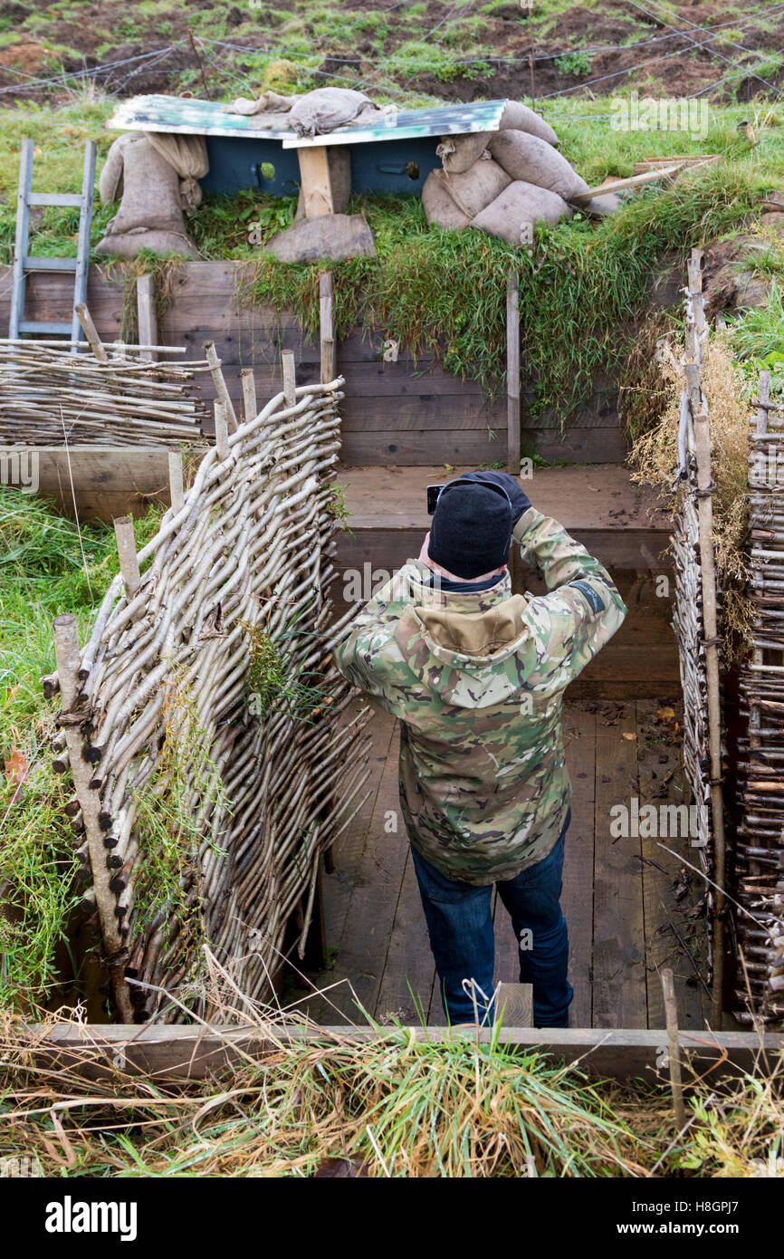 Glasgow, Scotland, Regno Unito. 12 Novembre, 2016. 'DIGGING NELL' , con l aiuto da lettere, diari, fotografie e manuali ufficiali, ricostruito WW1 trincee in Glasgow's Pollok Park, per creare un mozzo per l'apprendimento attivo sulle esperienze umane del conflitto e aiutare ad esplorare il modo in cui i soldati hanno fronteggiato in pericolose e ambienti stressanti. Qui JOIHN EVANS da Glasgow prende le fotografie della lookout post in un stile tedesco trincea. Credito: Findlay/Alamy Live News Foto Stock
