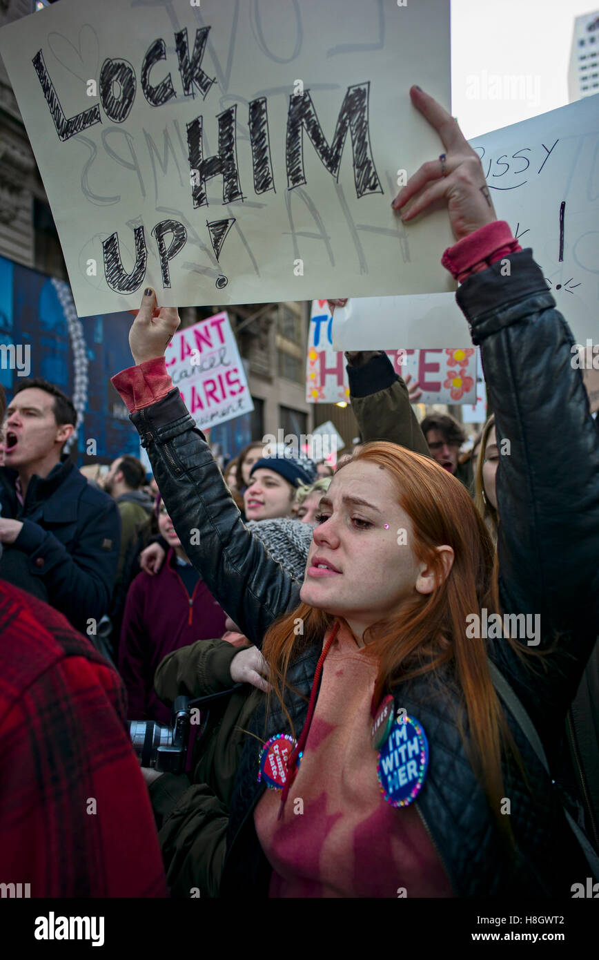 New York, Stati Uniti d'America. Novembre 12, 2016. Donna Holding firmano la lettura di "Lock lui!" durante il mese di marzo da New York City la Union Square fino la Quinta Avenue al Trump Tower per protestare contro le elezioni di Donald Trump come 45th presidente degli Stati Uniti Credito: Joseph Reid/Alamy Live News Foto Stock