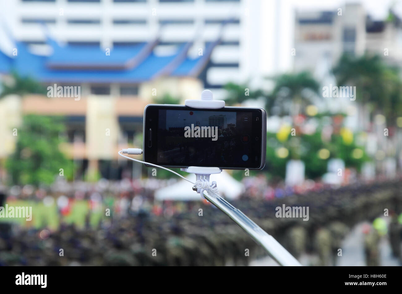 SEREMBAN, Malesia - 31 agosto 2016: una persona che fa caso una persona tenendo evento foto utilizzando il suo smartphone che è attaccato al selfie stick. Foto Stock