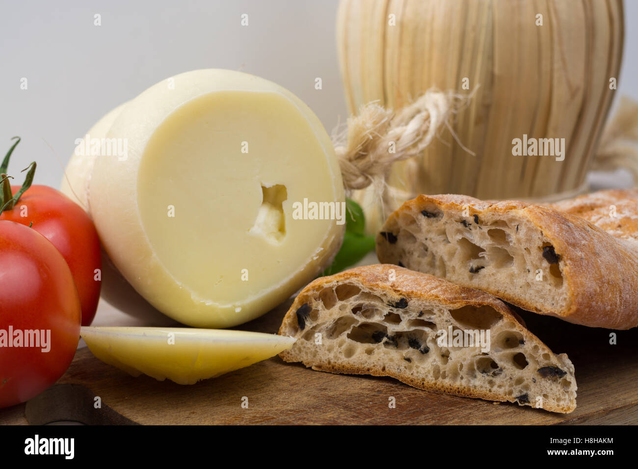 Miglior cibo italiano - fresco formaggio caciocavallo, vino rosso, pane con olive, pomodori Foto Stock