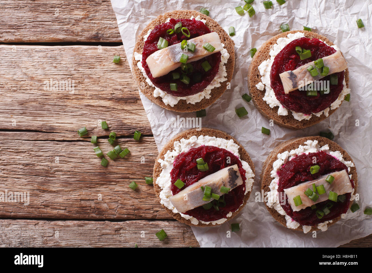 Sandwich scandinavo con aringa, la barbabietola e la crema di formaggio sulla tavola. vista orizzontale dal di sopra Foto Stock