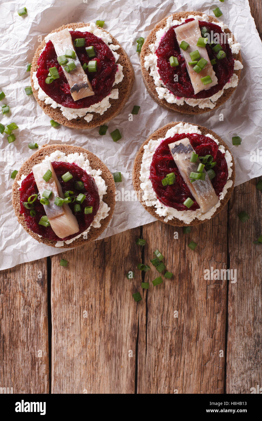 Sandwich scandinavo con aringa, la barbabietola e la crema di formaggio sulla tavola. vista verticale da sopra Foto Stock