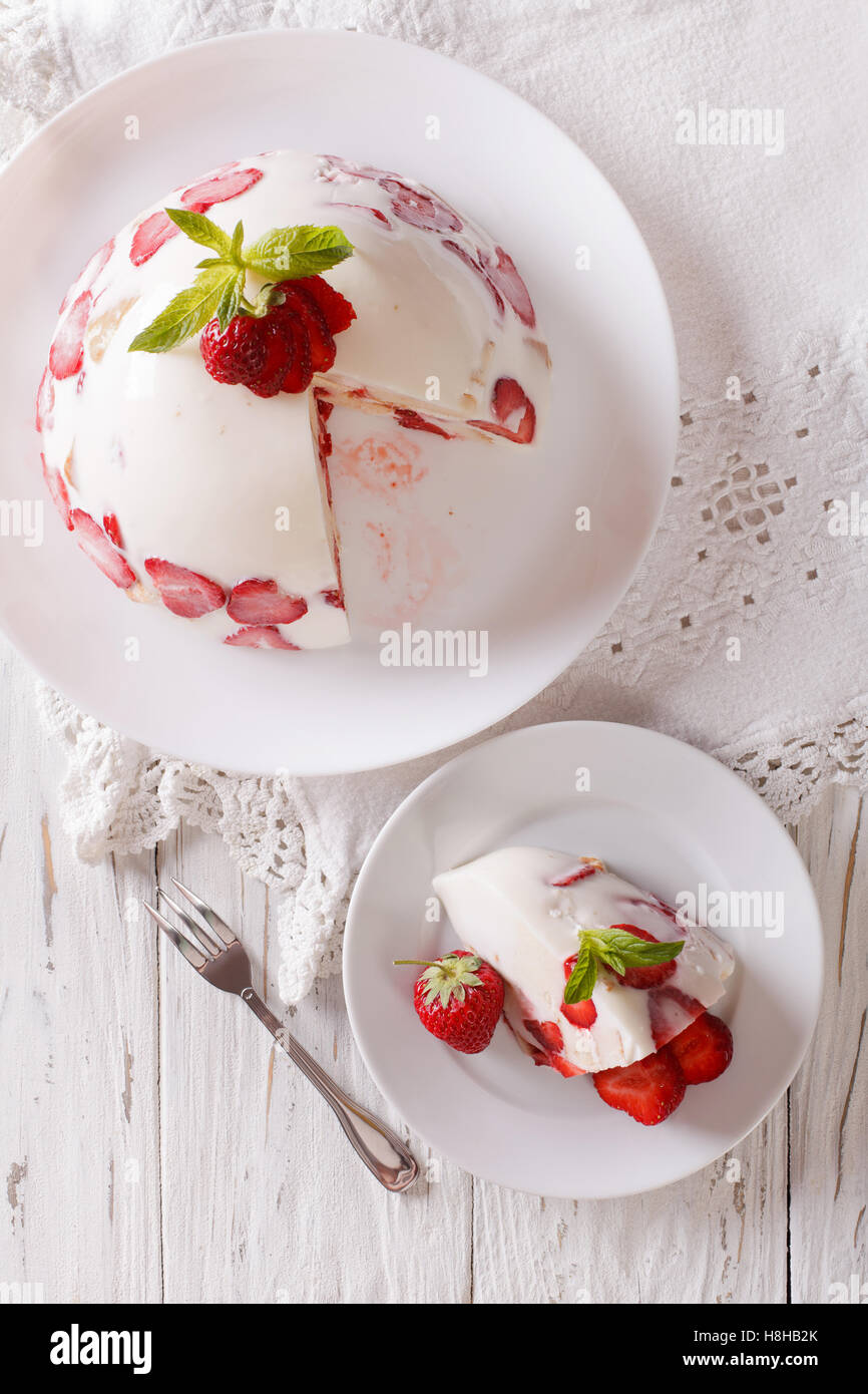 Cheesecake con fragole fresche su una piastra vicino. vista verticale da sopra Foto Stock