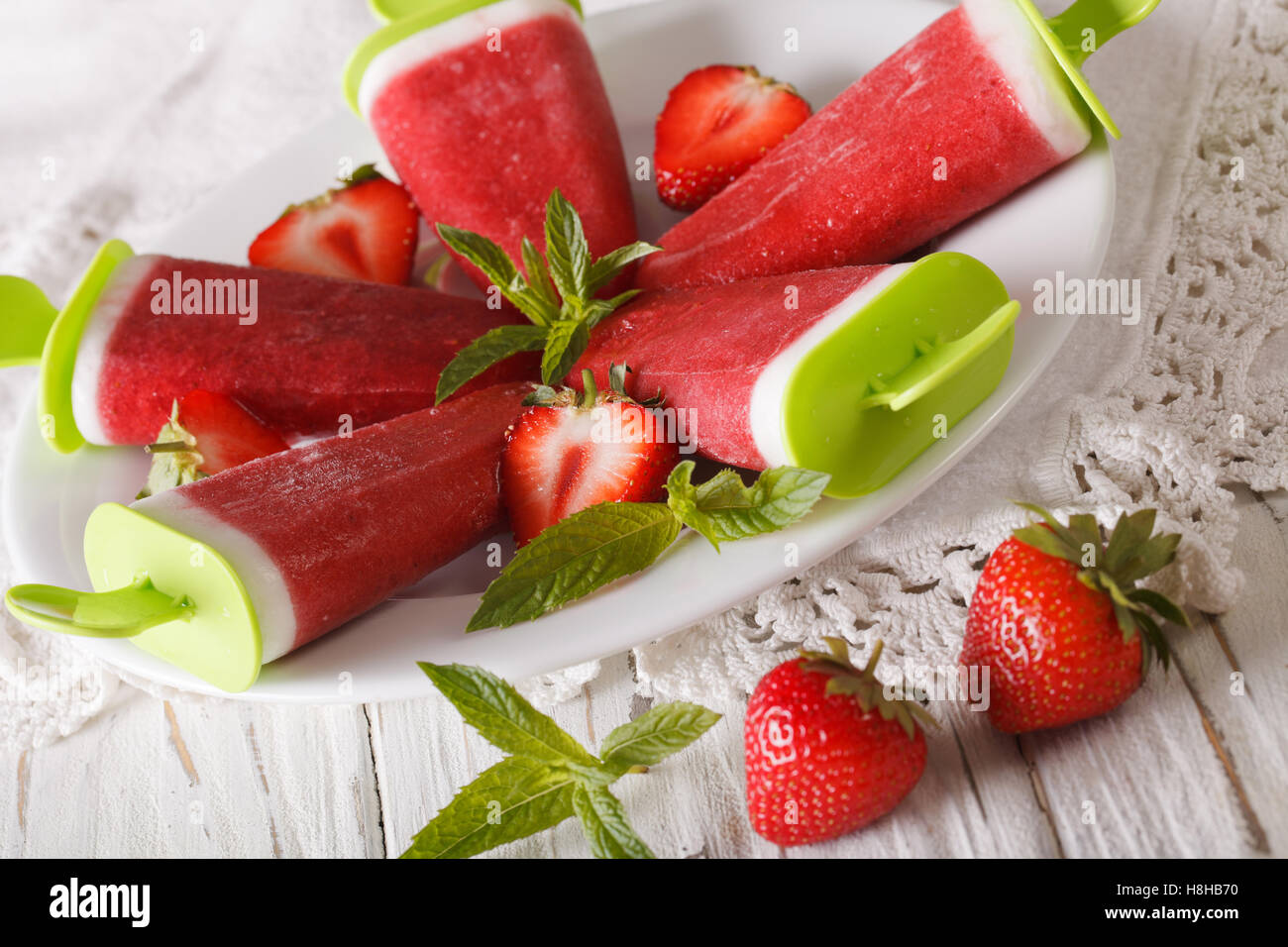 In casa fragola ghiaccioli su un bastone su una piastra di close-up orizzontale. Foto Stock