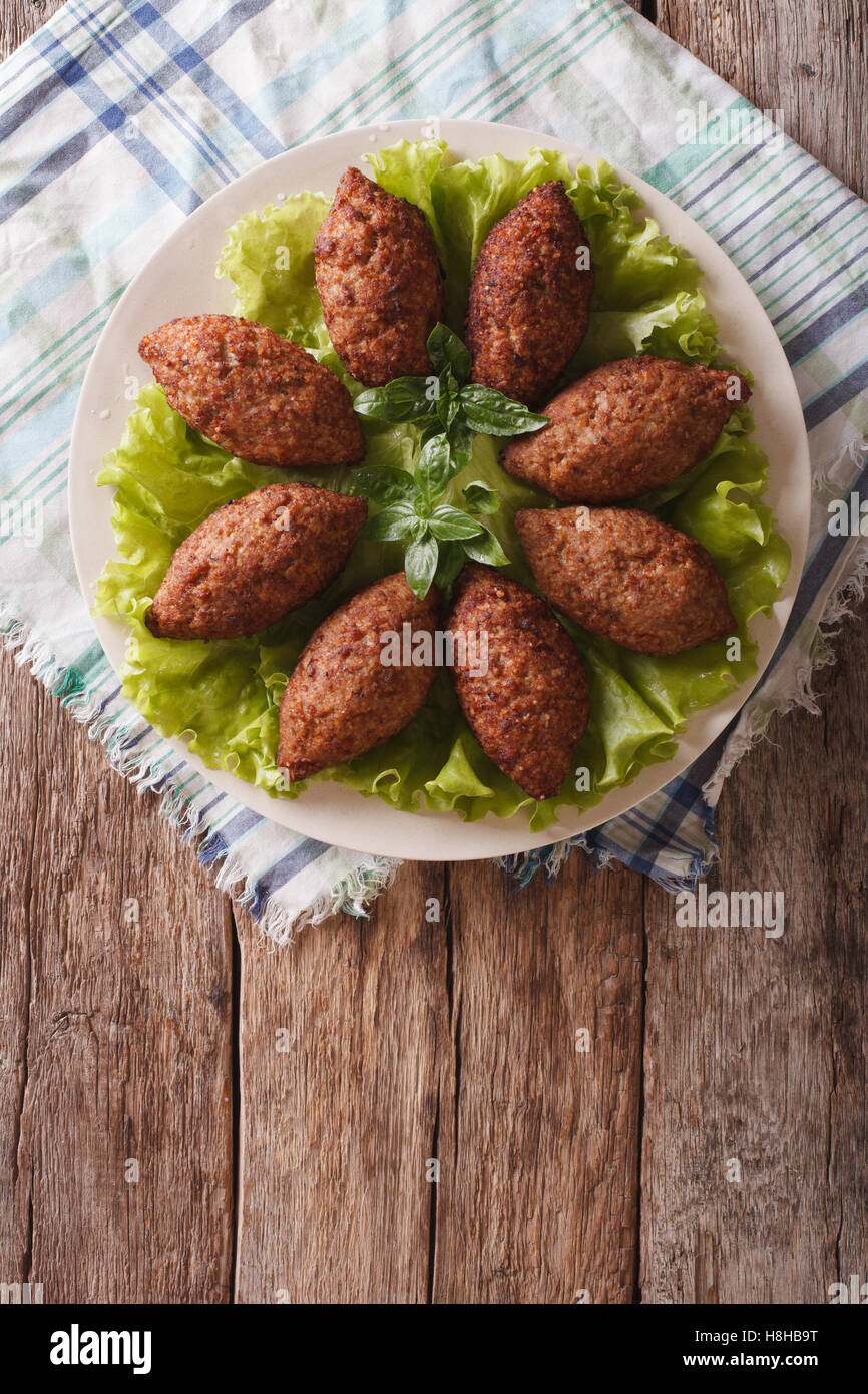 Cucina Araba: Carne Antipasto kibbeh close-up su una piastra. vista verticale da sopra Foto Stock