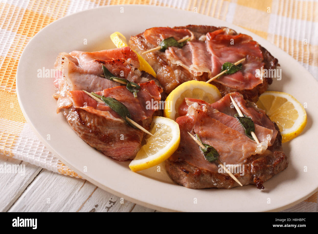 Italian Saltimbocca di Vitello con salvia, prosciutto e limone close-up su una piastra orizzontale. Foto Stock