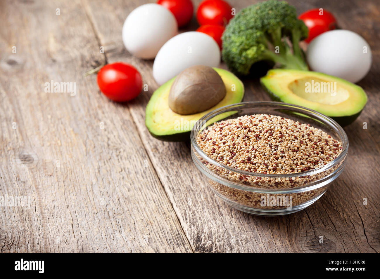 Ingredienti per fare una sana prima colazione. La quinoa con verdure fresche: avocado, pomodori, broccoli, uova sullo sfondo Foto Stock