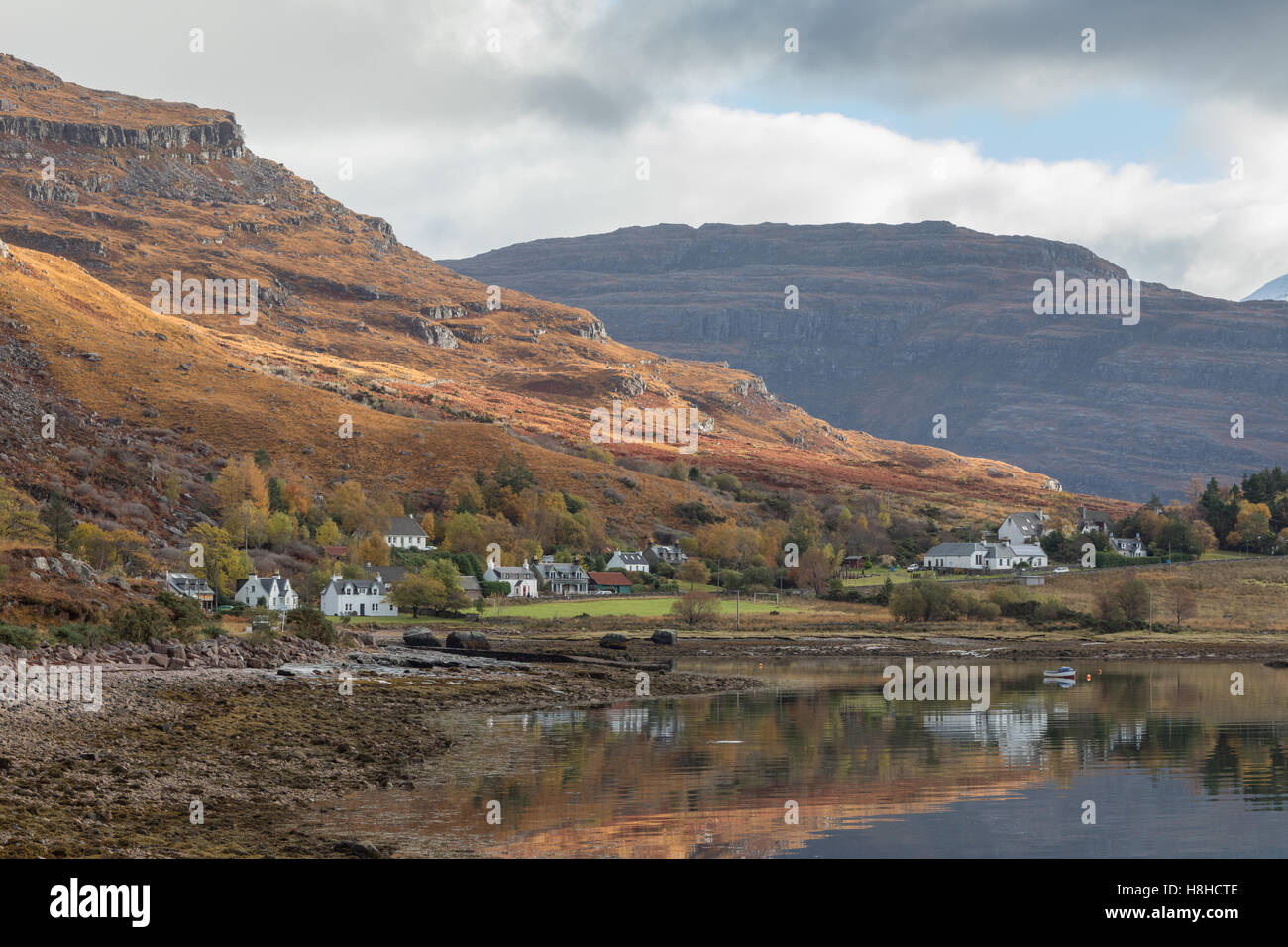 Le riflessioni di Torridon villaggio sulle rive di Loch superiore Torridon, Wester Ross, Scozia. Foto Stock