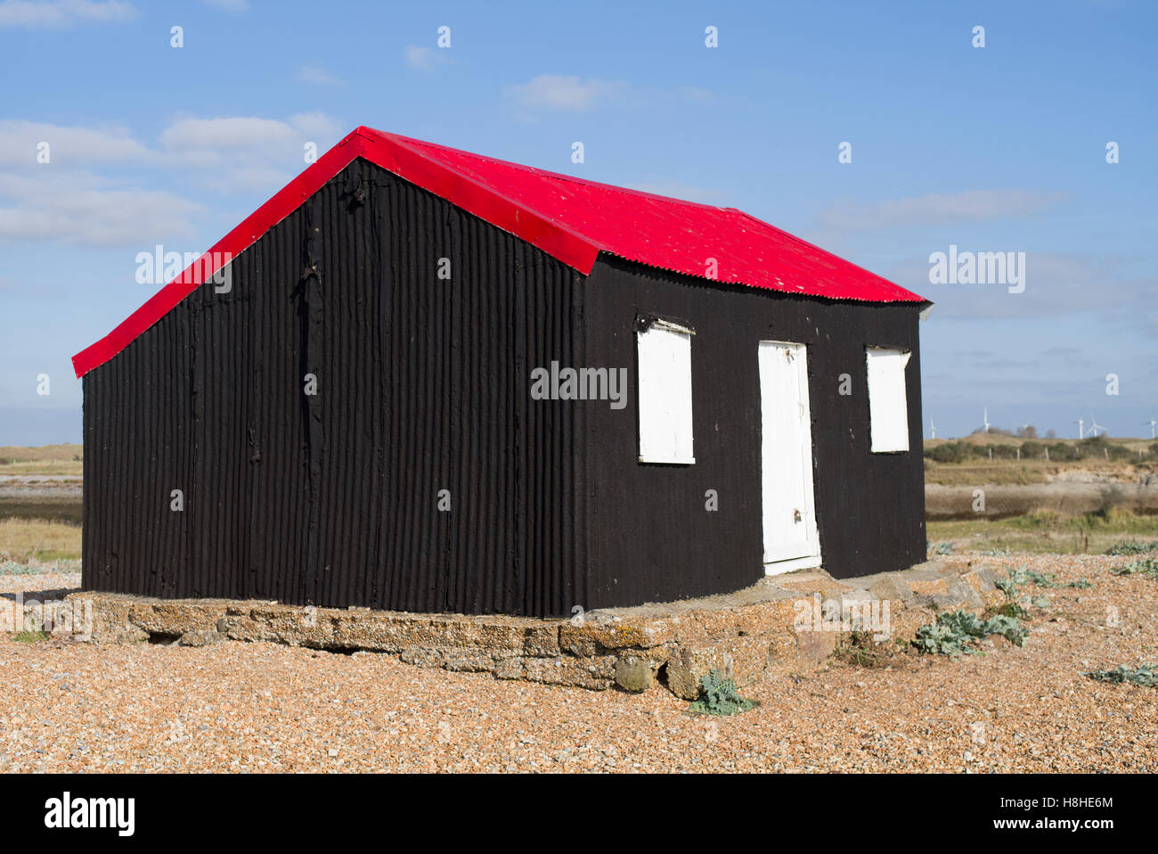 Solitario con colori vividi capanna sulla spiaggia di ciottoli a Rye in E. Sussex Foto Stock