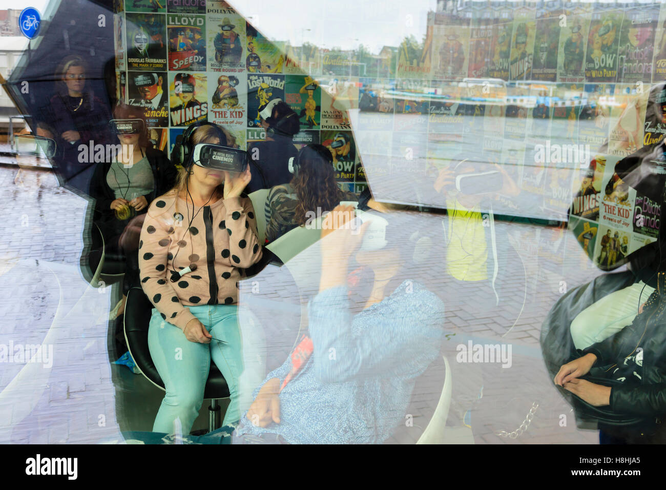 La gente che indossa la realtà virtuale set testa nella realtà virtuale Cinema Amsterdam, Paesi Bassi Foto Stock