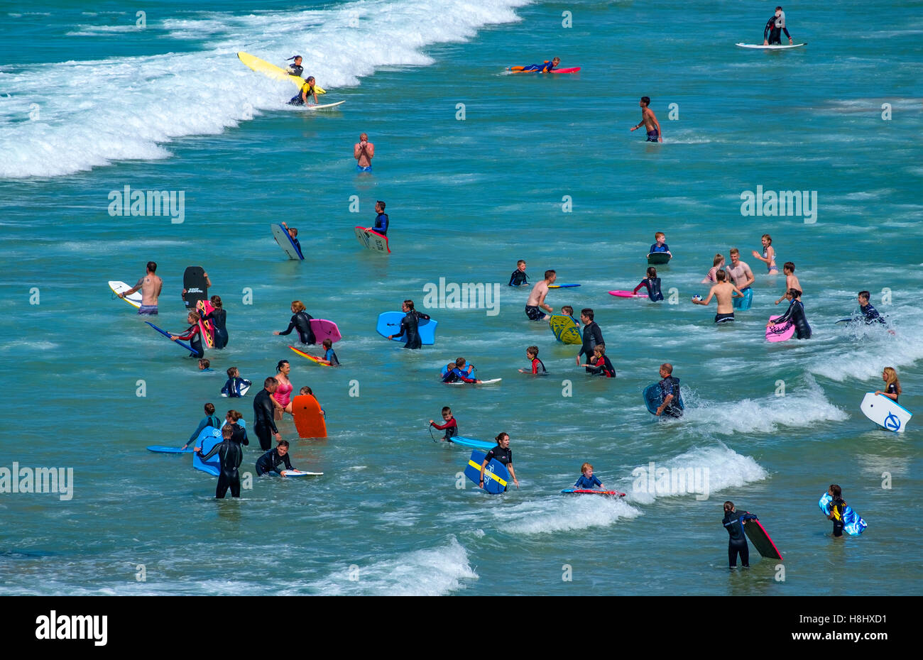 Surfisti di prendere il mare a Fistral Beach in Newquay, Cornwall, England, Regno Unito Foto Stock
