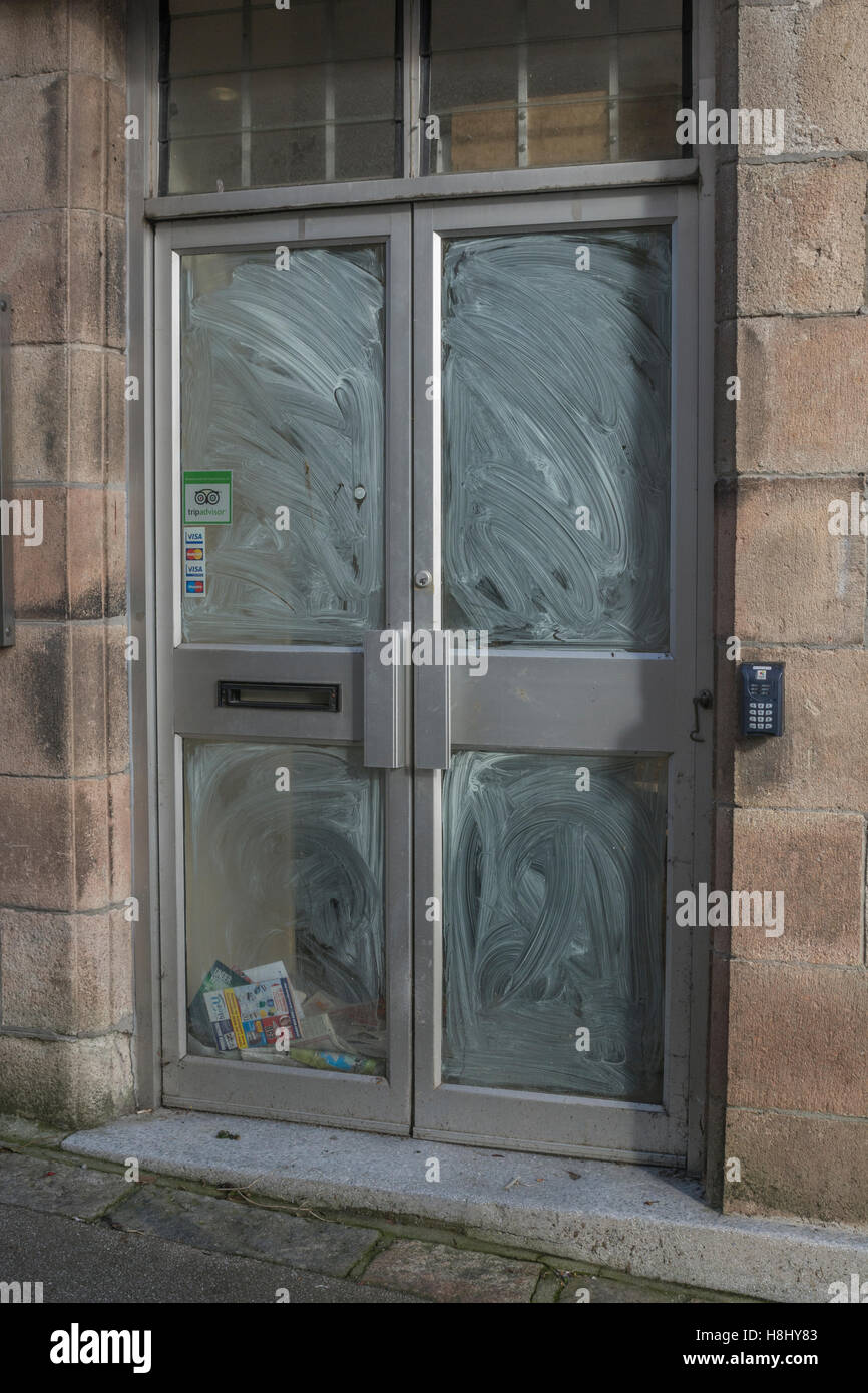 Closed shop locali - post non riscossi e volantini accumulando dietro la finestra del negozio. La morte della high street metafora. Foto Stock