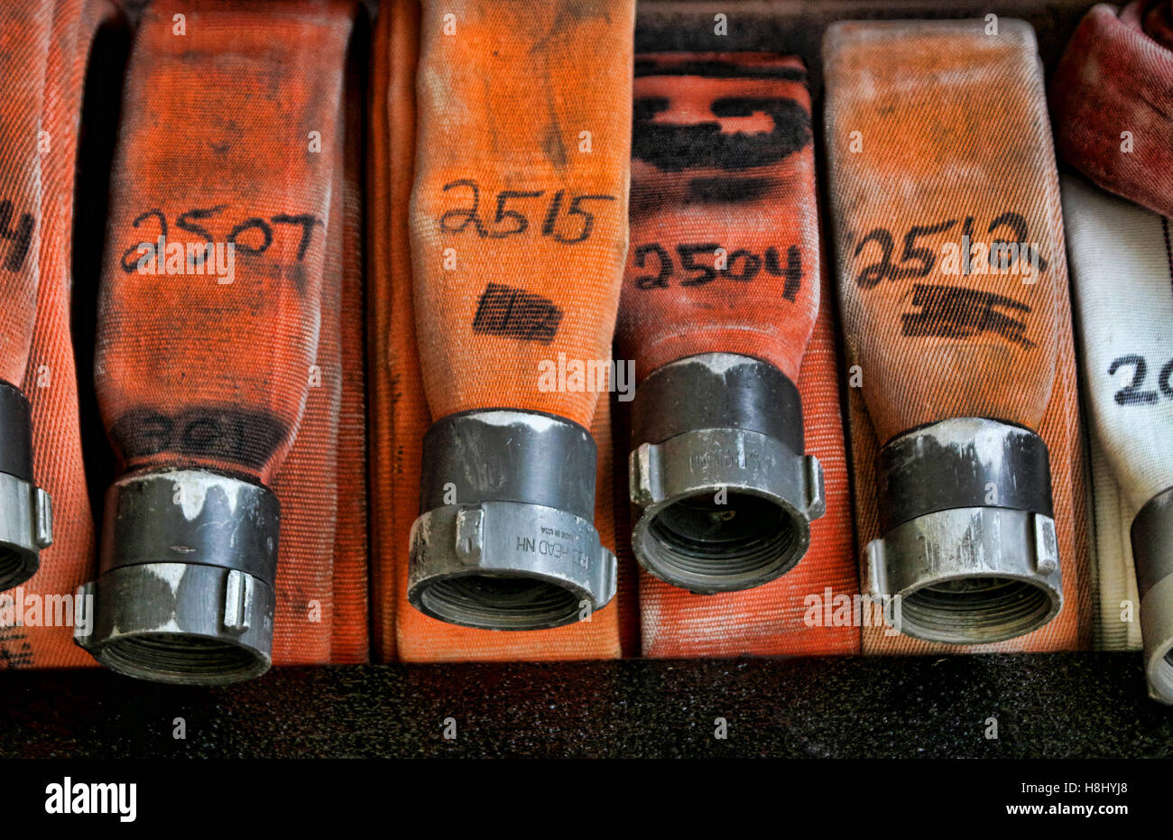 Orange tubo antincendio nella stazione dei vigili del fuoco Foto Stock