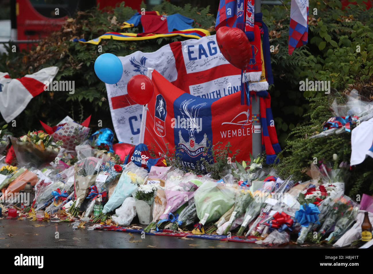 Omaggi floreali e Crystal Palace football colori a sinistra vicino alla scena dove un tram, precipitò uccidendo 7 persone a Croydon, a sud di Londra. Foto Stock
