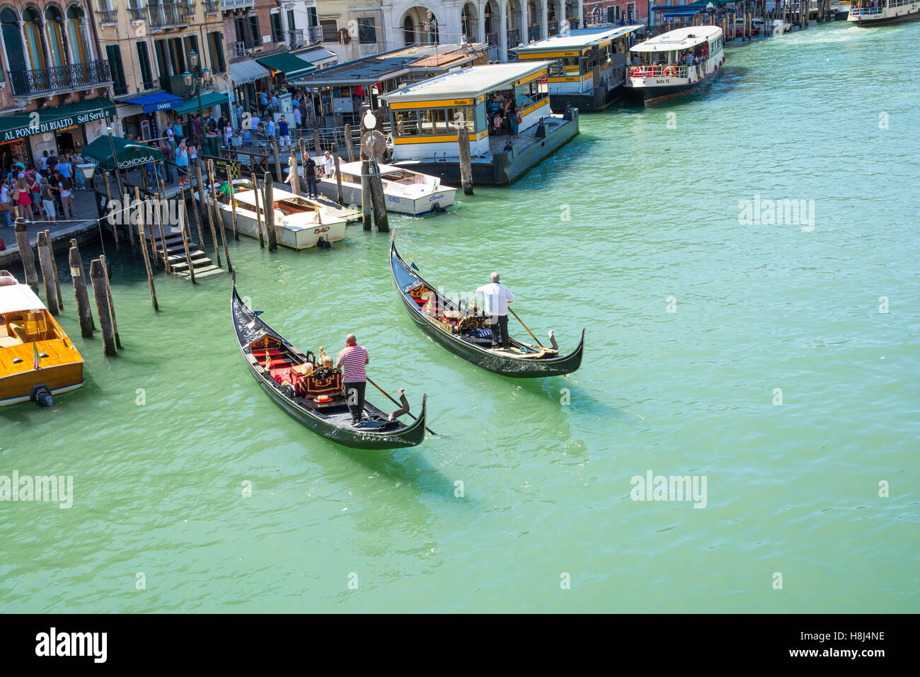 Venezia,Italy-August 17,2014:due gondolieri portano i turisti in una romantica gita sul Canal Grande a Venezia durante un giorno di estate Foto Stock