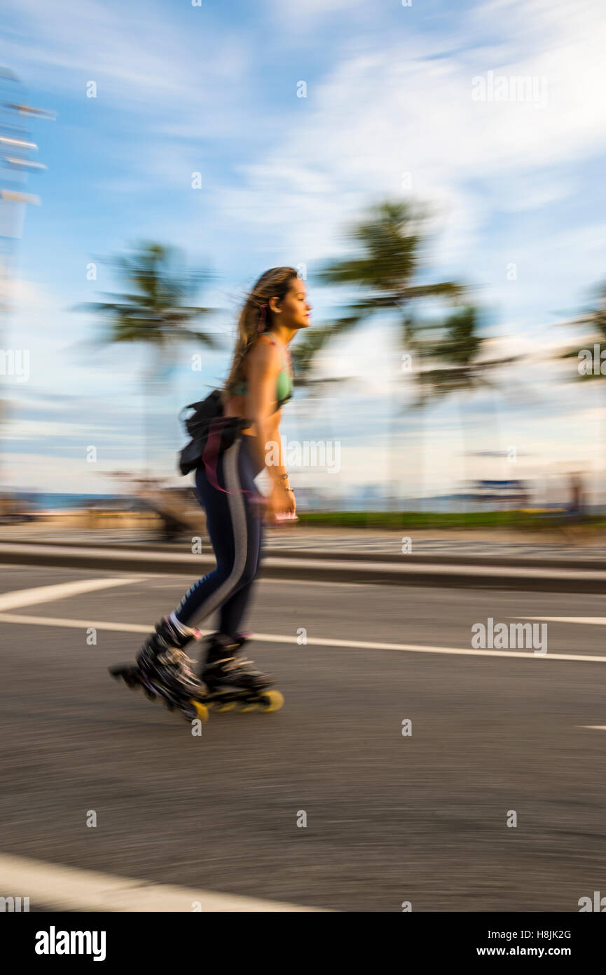RIO DE JANEIRO - Marzo 6, 2016: un giovane carioca donna brasiliana pattini in una sfocatura di movimento lungo la spiaggia di Ipanema. Foto Stock