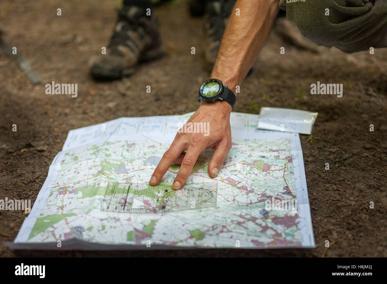 Un gruppo di escursionisti utilizza la mappa e la bussola per navigare attraverso la foresta Foto Stock
