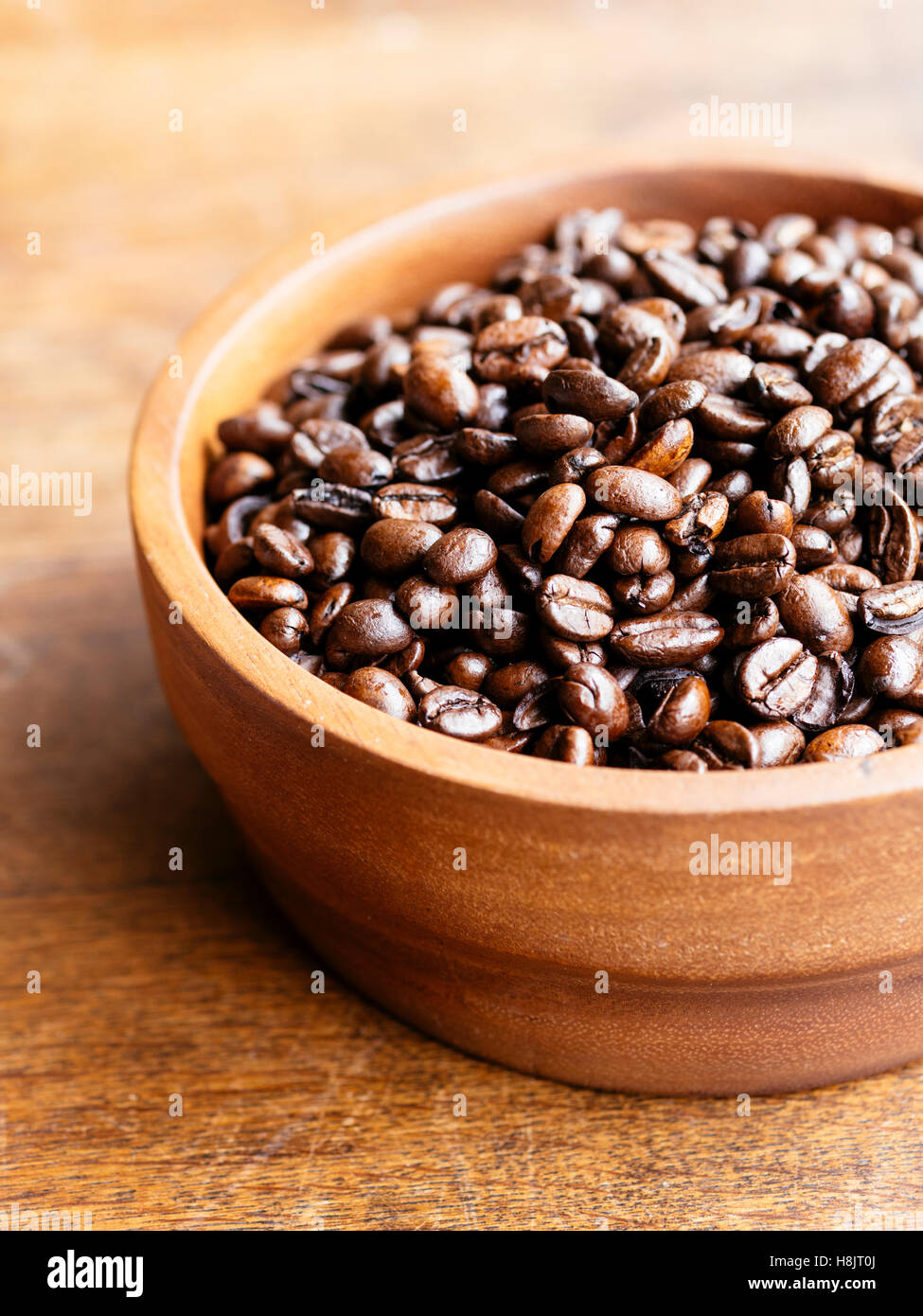 Organici di chicchi di caffè in una ciotola di legno Foto Stock