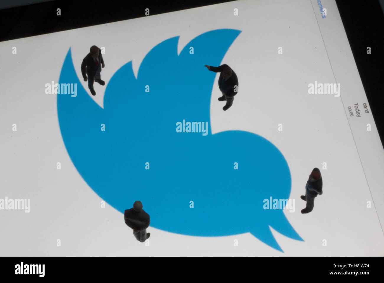 Modelli in scala di persone poste nella parte anteriore del logo twitter marchio su ipad Foto Stock