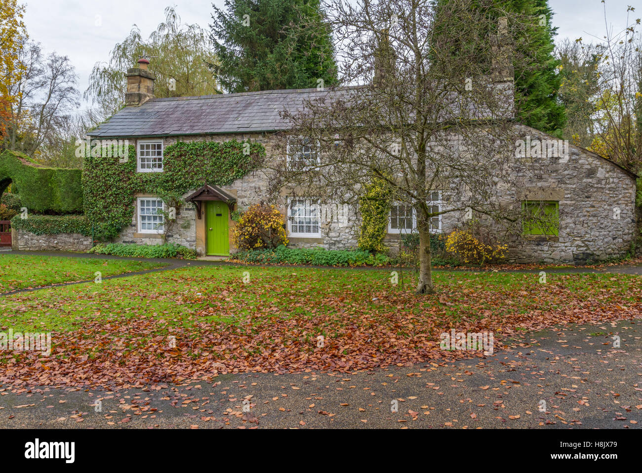 Il cottage in autunno che è situato accanto al ponte sheepwash sul fiume Wye nel villaggio di Ashford in acqua Foto Stock