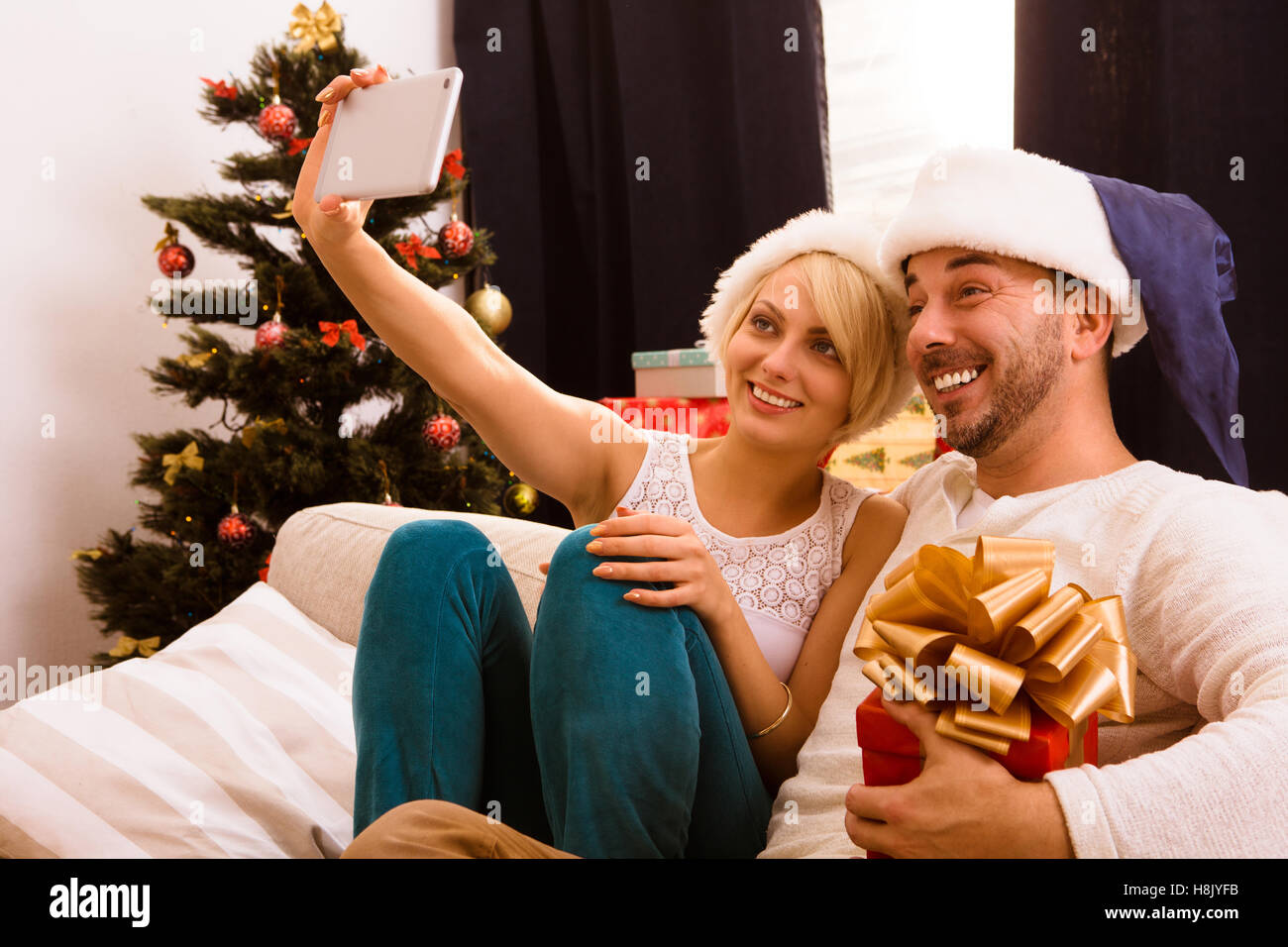 Felice Natale giovane rendendo self foto a casa Foto Stock