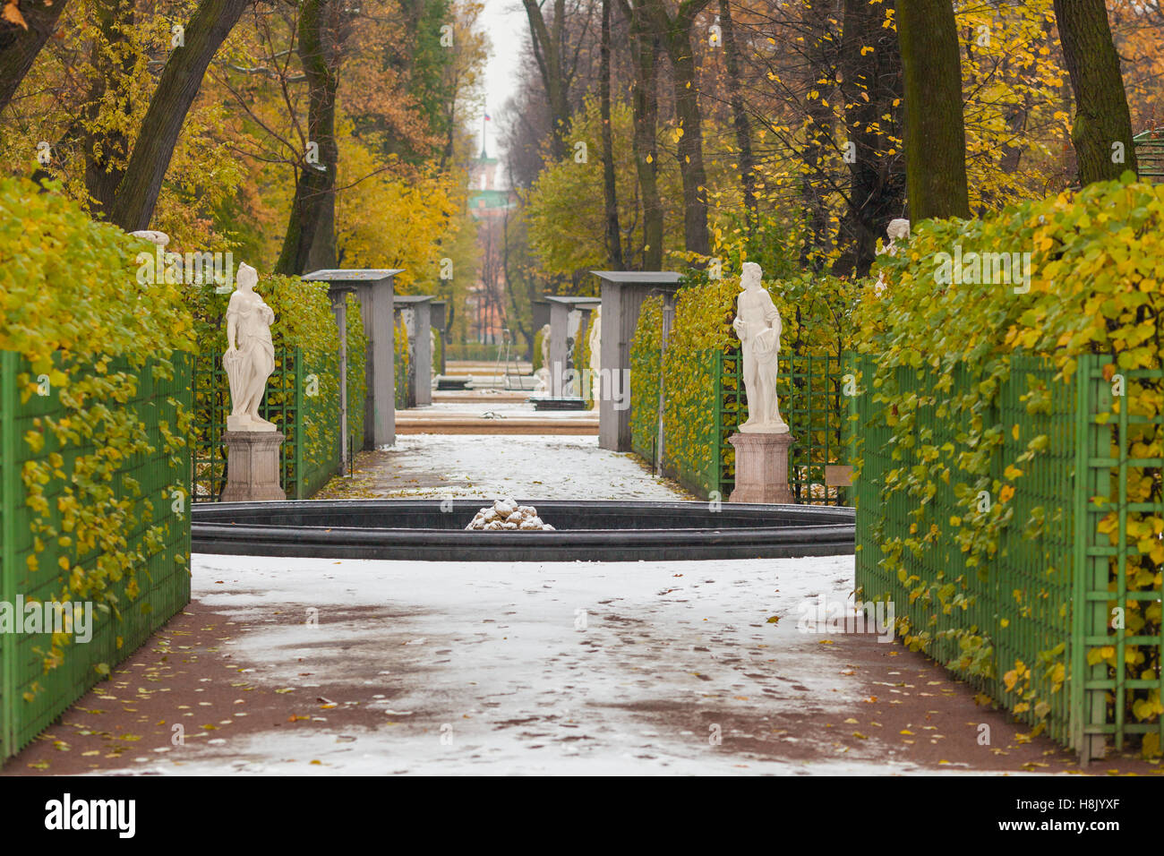 Vista sul viale centrale nel giardino estivo dopo la prima nevicata, San Pietroburgo, Russia Foto Stock