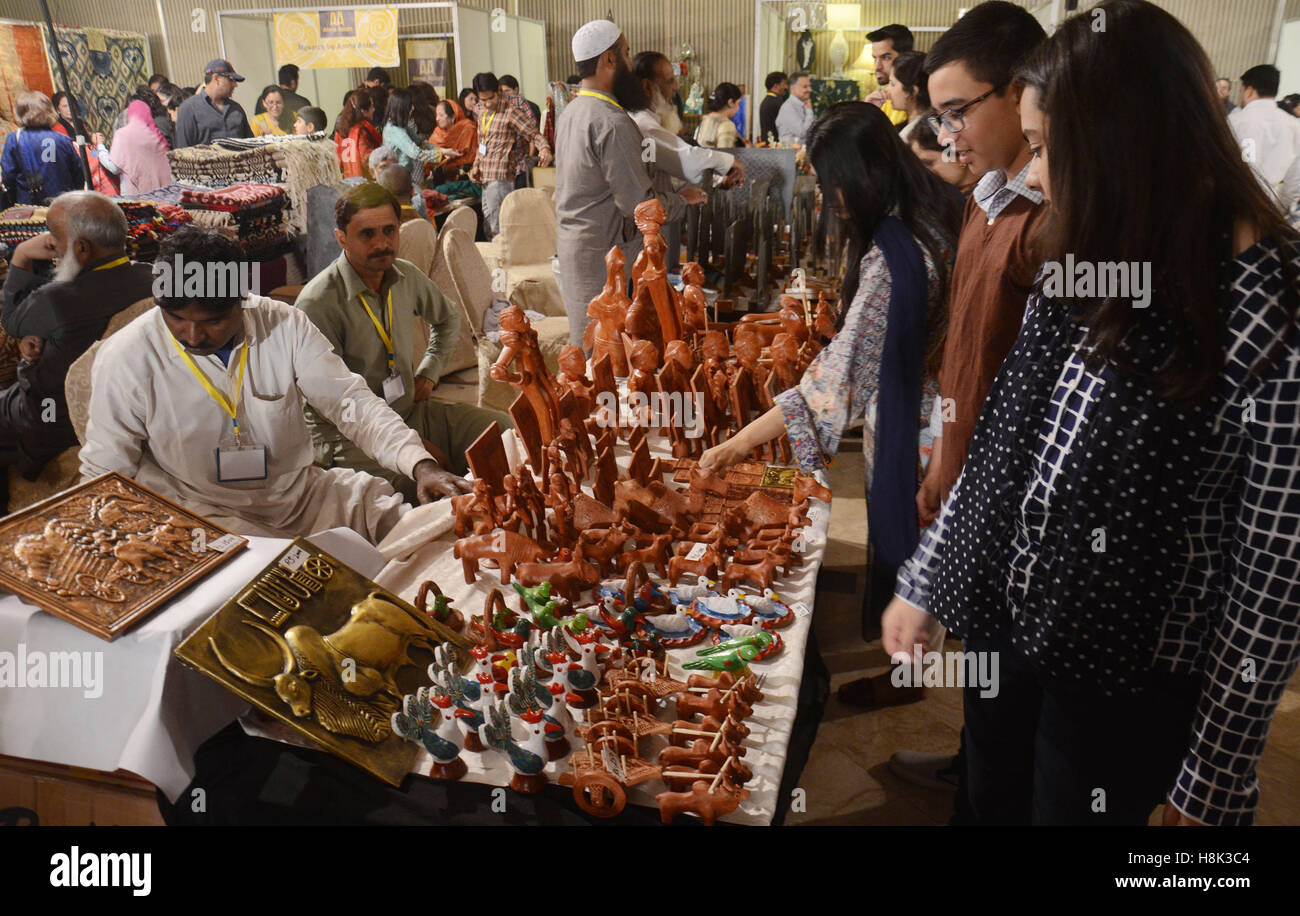 Lahore, Pakistan. Xiii Nov, 2016. Visitatori pakistano tenendo interesse per gli elementi visualizzati durante il secondo giorno del (DAACHI) Arti e Mestieri Fiera mostra organizzata dalla Fondazione Daachi. Prodotti fatti a mano contenente tessuti, ceramiche, Hunza scialli, gioielli etnici, artigianato da Gilgit, Hyderabadi schiave, Phulkari da Haripur, Taxila sculture in pietra, mobili dipinti a mano, chioschi, arte carrello merci, chioschi, dipinti arti e mestieri. © Rana Sajid Hussain/Pacific Press/Alamy Live News Foto Stock