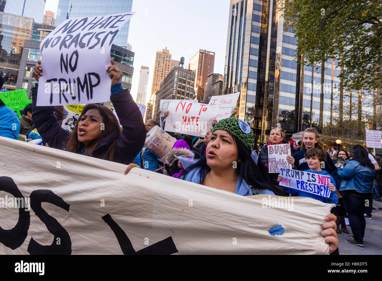 New York, Stati Uniti d'America 12 Novembre 2016 - Cinque giorni dopo le elezioni presidenziali anti-Trump manifestanti marzo dal Trump Hotel and Towers in Columbus Circle, al Trump Tower sulla Quinta Avenue. Il rally dal titolo Siamo qui per questo soggiorno è stato organizzato da diversi gruppi di immigrati in risposta al Presidente eletto Donald trionfi campagna promessa di deportare gli immigrati clandestini. Credito: Stacy Rosenstock Walsh / Alamy Foto Stock