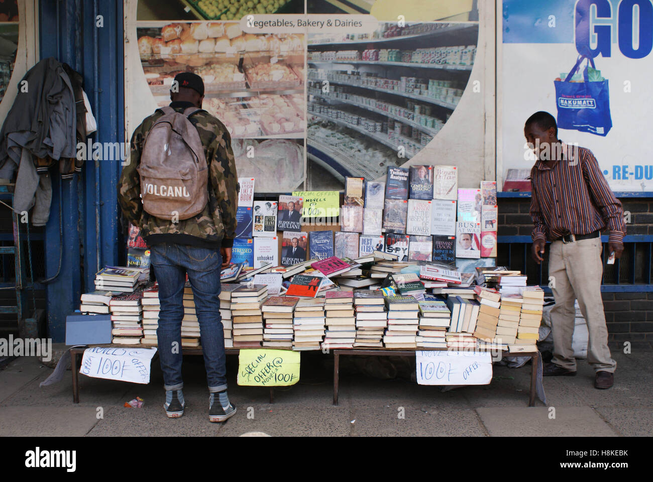 Prenota vendor Norman Maina (R) cerca di convincere un cliente dell'acquisto di un libro nella capitale del Kenya, Nairobi, 23 ottobre 2016. Il suo libro Il supporto può essere trovato su Viale Moi tra una stazione degli autobus e a un super mercato. Foto: Anja Bengelstorff/dpa Foto Stock