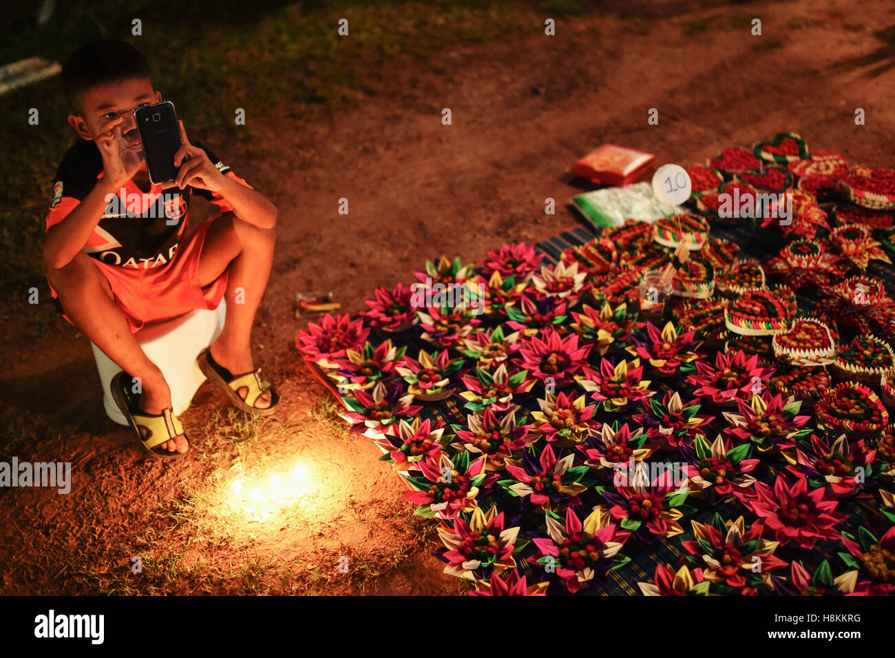 Bangkok. Xii Nov, 2016. Foto scattata il 9 novembre 12, 2016, mostra un giovane distributore vende Krathongs all'interno di The Sukhothai Historical Park, Thailandia. Thailandia osservato l annuale Loy Krathong festival il lunedì. Come una tradizione che è stata seguita per almeno sette secoli, le persone insieme a galla lotus-zattere sagomata adornata con candele, incenso e fiori, noto come Krathongs, attorno alla dodicesima notte di luna piena del calendario tailandese e di augurare a un anno con la sfortuna di essere lavati via dalle acque. © Li Mangmang/Xinhua/Alamy Live News Foto Stock