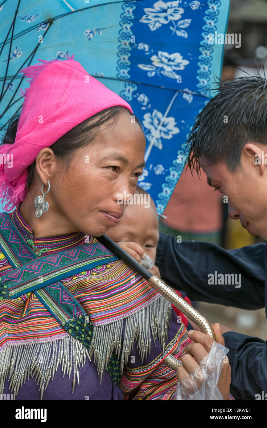 Momento di gara, fiore donna Hmong, mio marito e il bambino, Coc Ly mercato nella pioggia, vicino a Sa Pa, Vietnam del nord Foto Stock