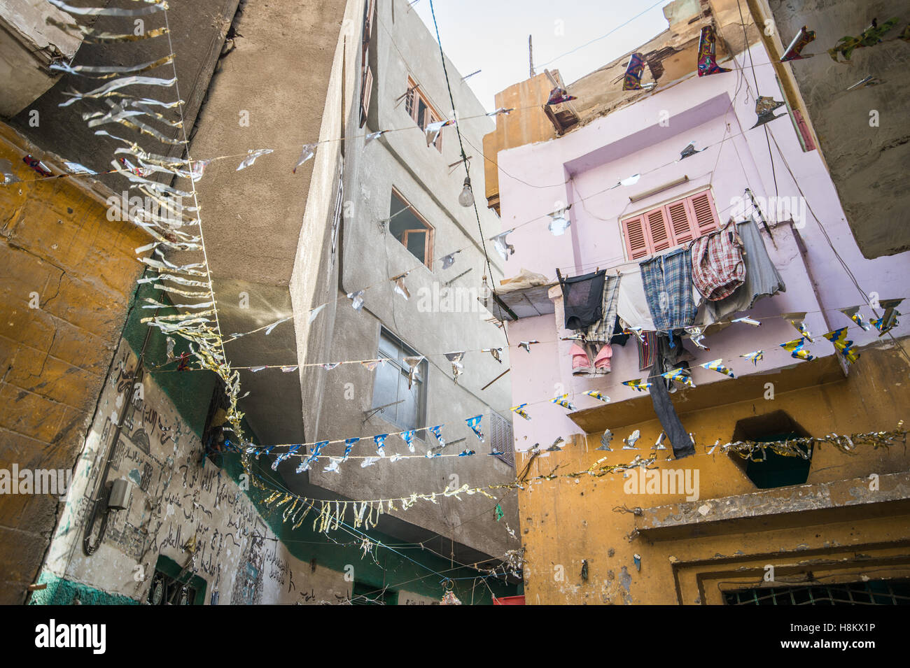 Il Cairo, Egitto. Guardando verso l'alto appartamento edifici con biancheria stesa ad asciugare in un vicolo vicino al bazaar all'aperto/ flea mar Foto Stock