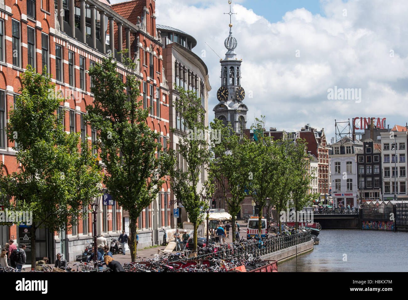 Amsterdam, Paesi Bassi vista sul lungomare di turisti a piedi lungo un canale di Amsterdam. In fondo è Torre Munt lungo con Foto Stock