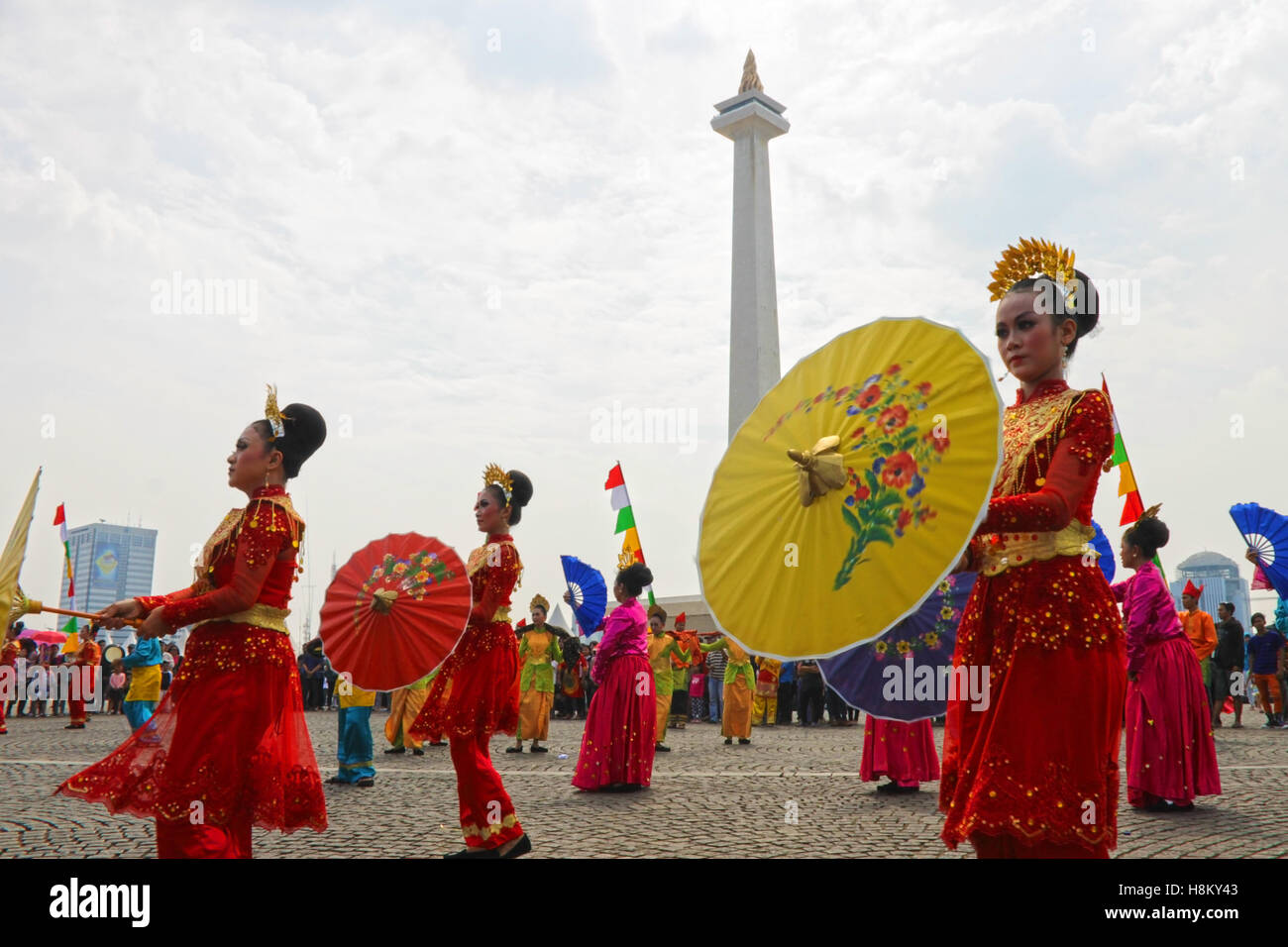 Bella ballerini in costume tradizionale da Jambi, Indonesia mostra un ombrello danza per gli spettatori in un carnevale. Foto Stock