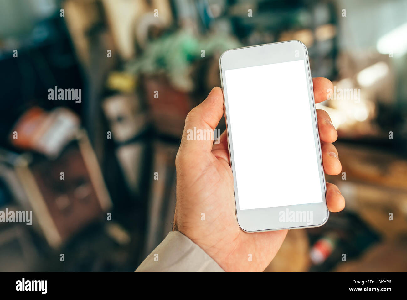 Maschio di mano azienda white smartphone con schermo vuoto come spazio di copia Foto Stock