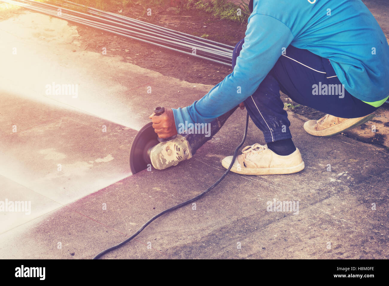 Close up man mano il taglio di pavimenti in calcestruzzo con la macchina. Foto Stock