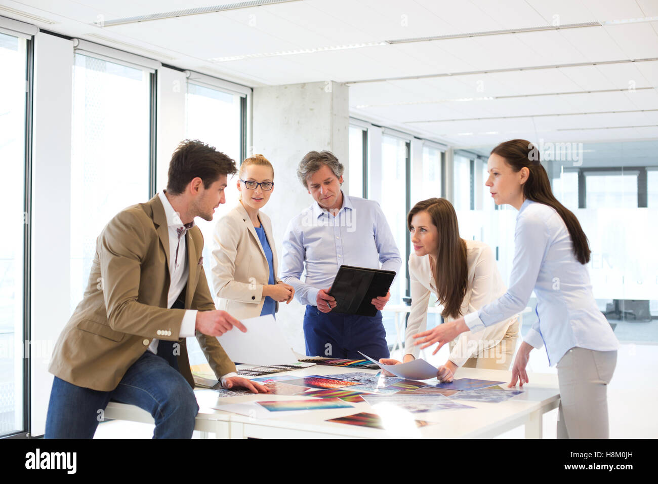 Maschio e femmina design professionisti aventi la discussione a tavola nel nuovo ufficio Foto Stock