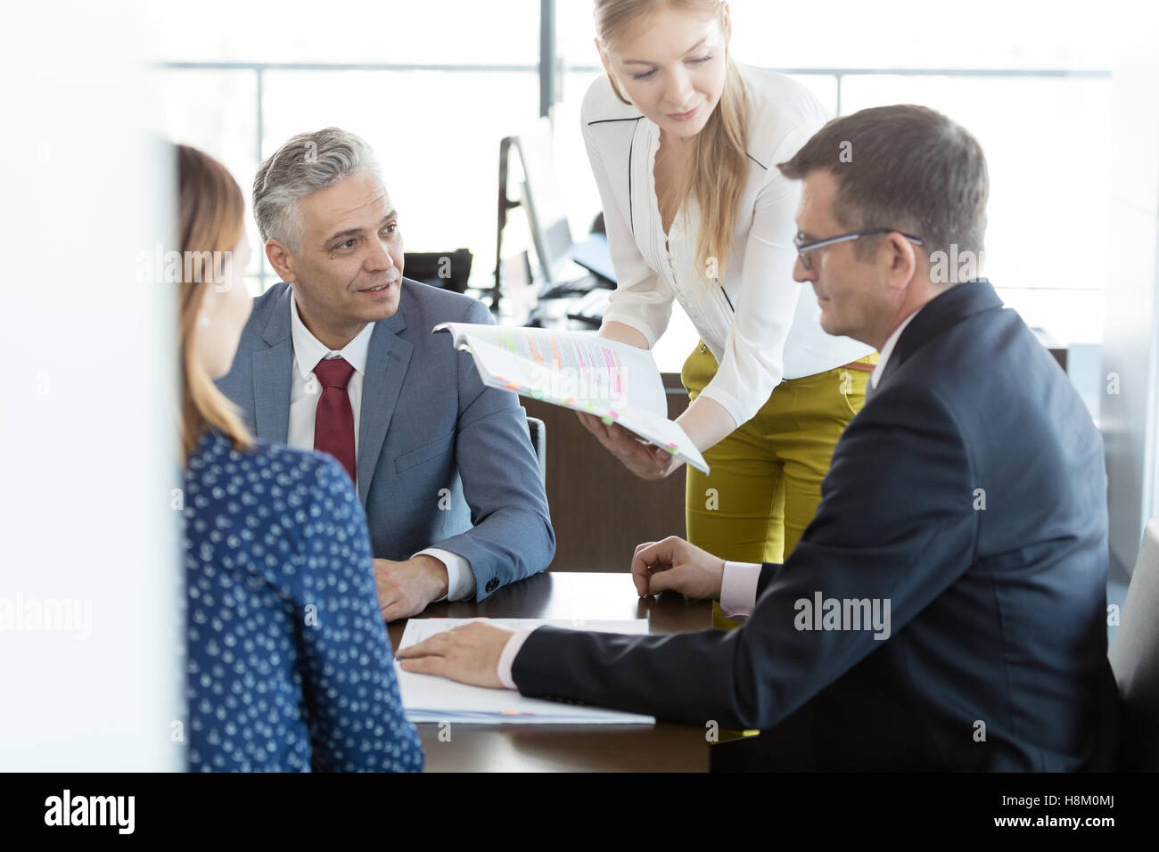Imprenditori e imprenditrici in discussione con il progetto nella sala riunioni Foto Stock