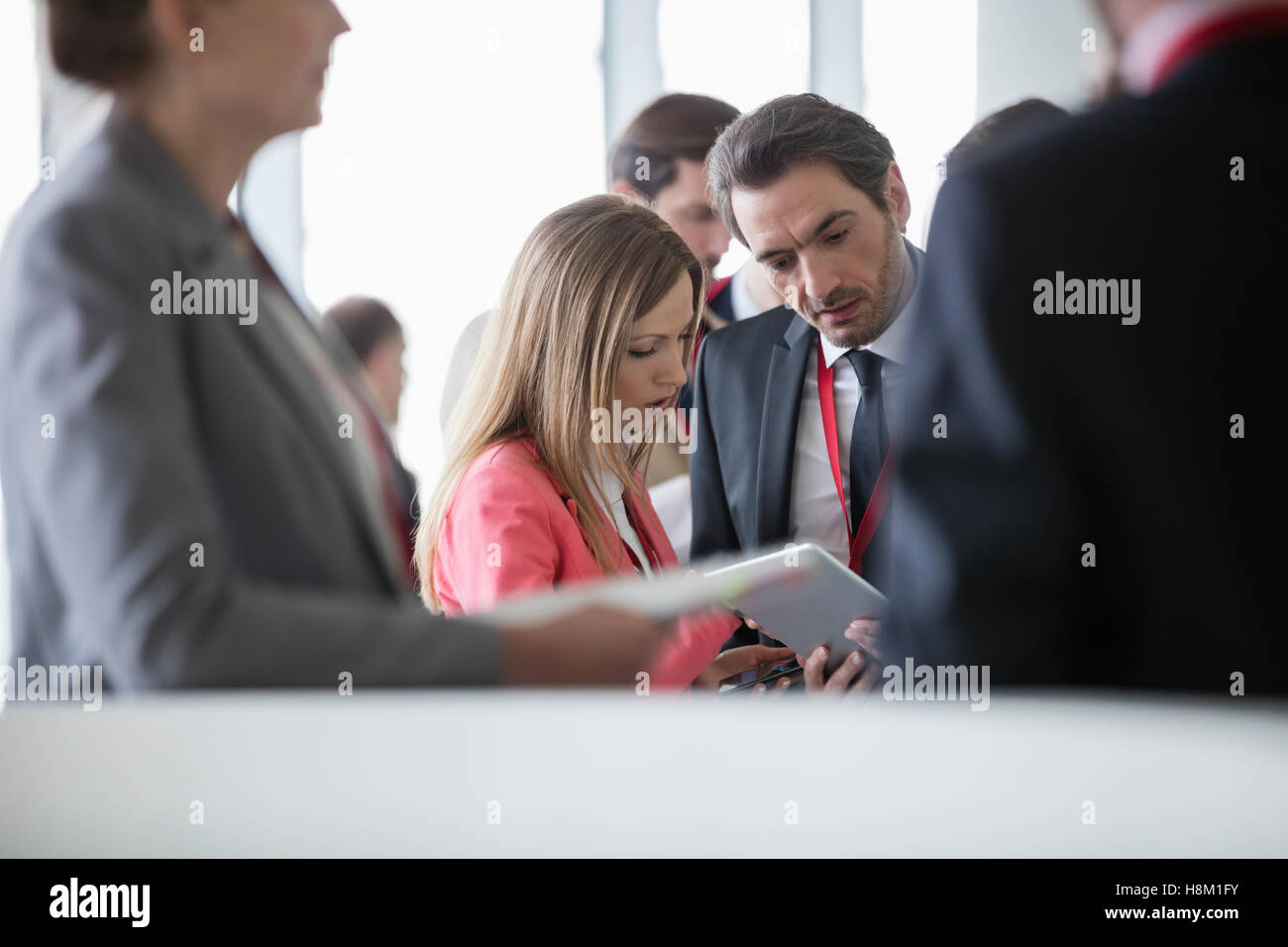 La gente di affari con tavoletta digitale nel convention center Foto Stock