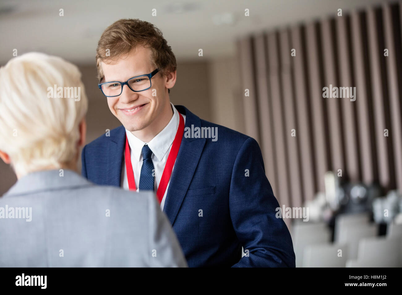 Happy businessman guardando il collega in sala per seminari Foto Stock