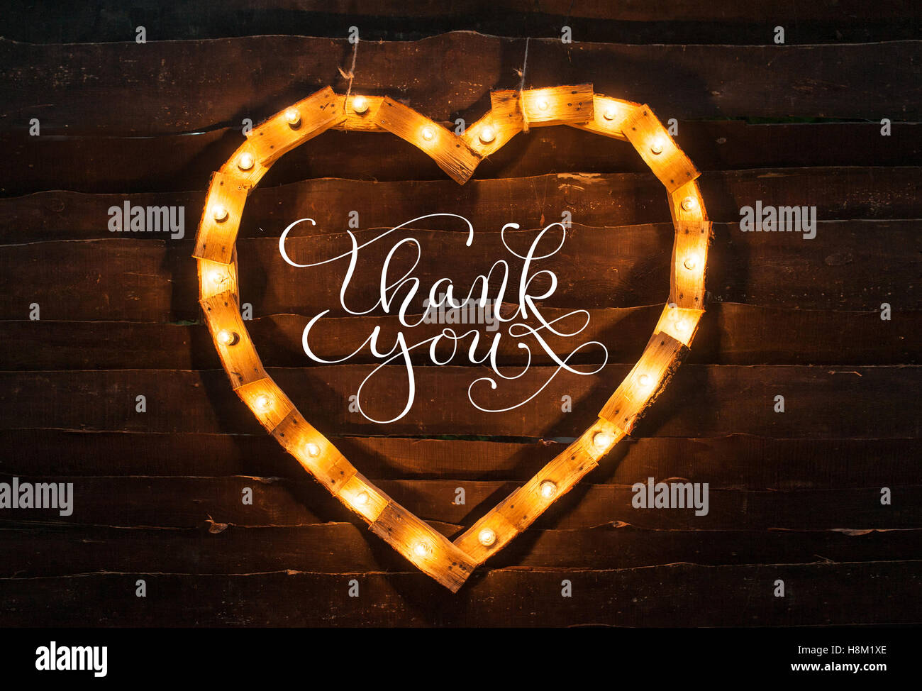 Cuore di luci su uno sfondo scuro e parole grazie Foto Stock