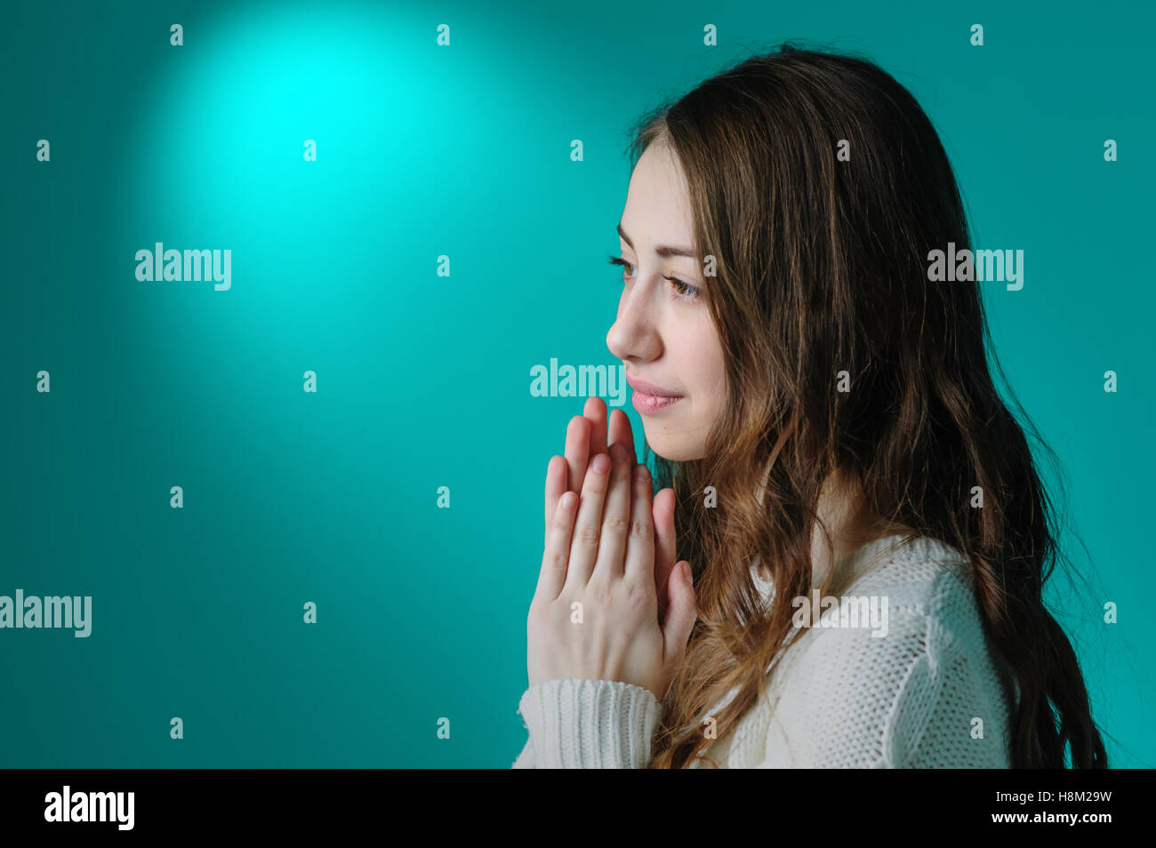 Giovane bella donna che prega in una stanza Foto Stock