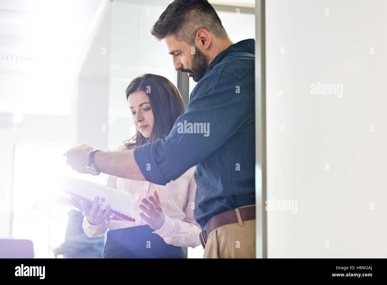 Imprenditore con collega femmina revisione di progetto in ufficio Foto Stock