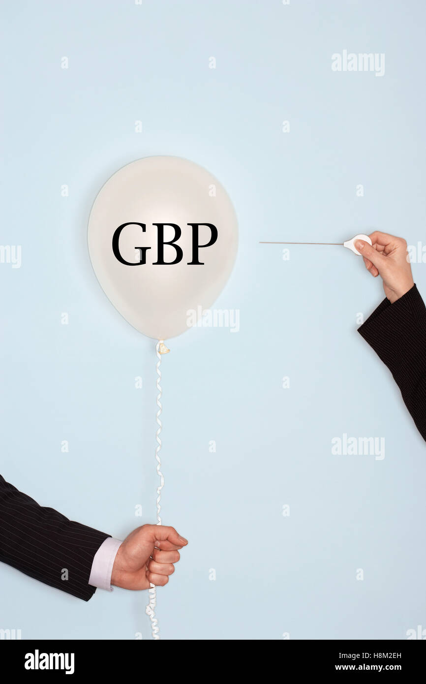 Mani tagliate azienda ago e scoppiettante palloncino con il testo che dice GBP Foto Stock